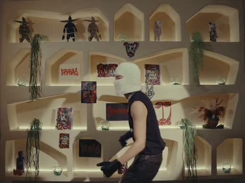 RAW 001, frame 15: a masked dancer in a white mask and black vest