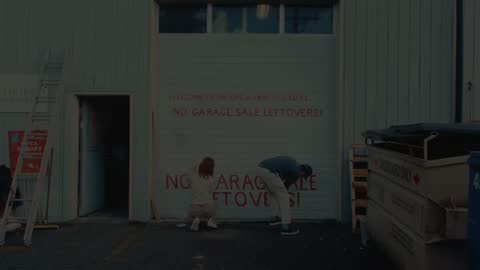 SPCA, frame 01: wide shot of two painters at a garage door wall in a back lane