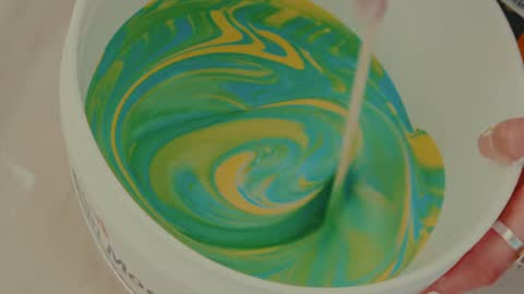SPCA, frame 07: swirls of green and yellow paint in a bucket