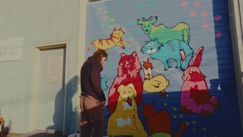 SPCA, frame 11: the finished mural of cats and rabbits on the garage door